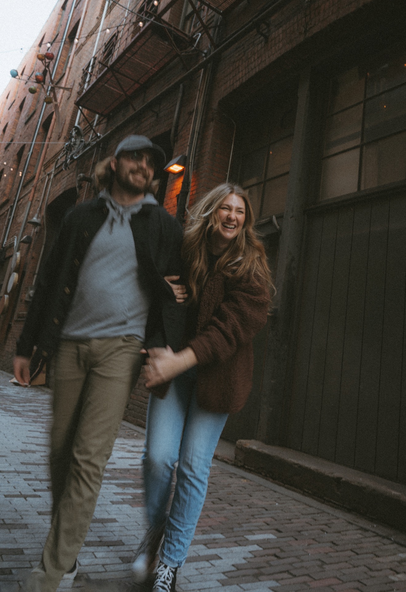 A portrait of a male and a female couple walking and laughing in alleyway near Pioneer Square, Seattle.