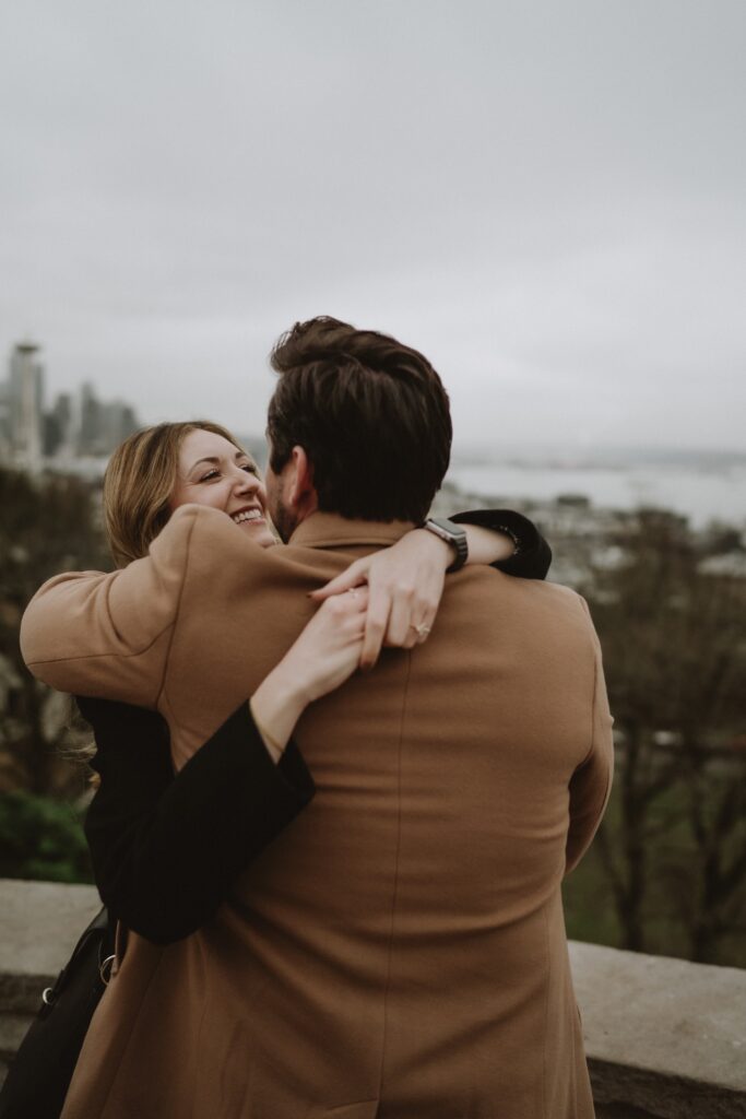 A couples portrait of a male and female embracing in hug at Kerry Park near Seattle, WA