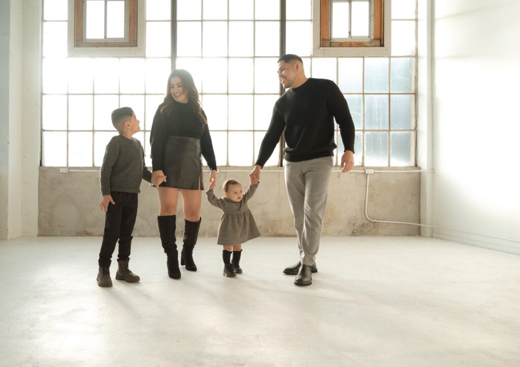 A family studio portrait of male and female walking with two children at Northlight Studio near Seattle, WA