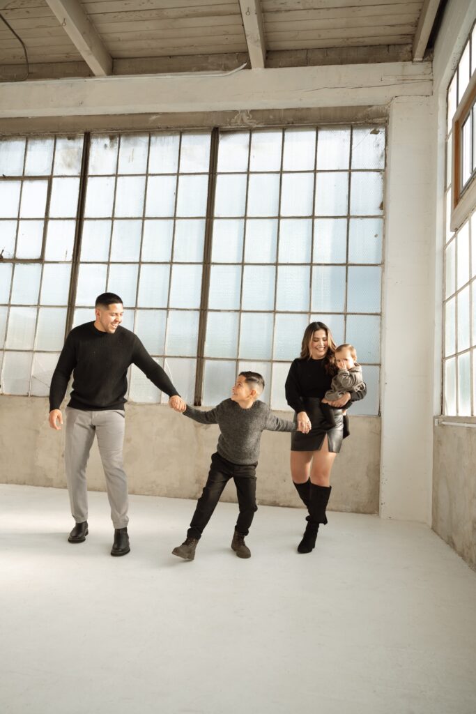 A family studio portrait of male and female playing with two children at Northlight Studio near Seattle, WA