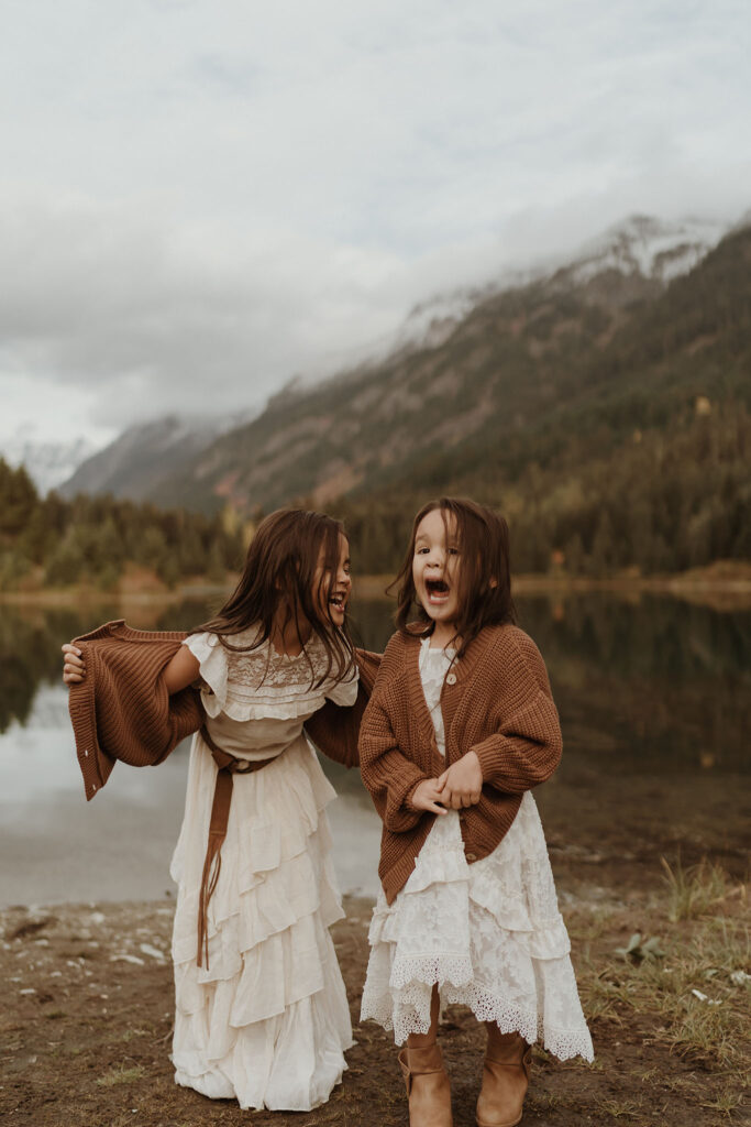 A children's portrait of two little girls wearing white dresses playing at Gold Creek Pond near Snoqualmie Pass, Seattle, WA.