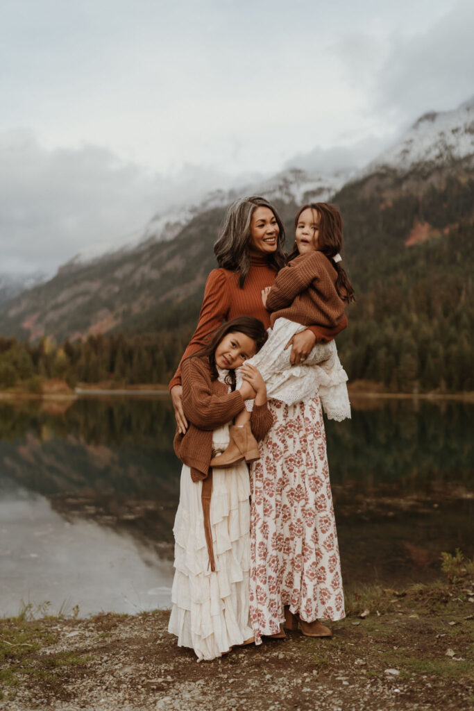 A family portrait of a female wearing long skirt standing with little girls at Gold Creek Pond near Snoqualmie Pass, Seattle, WA.