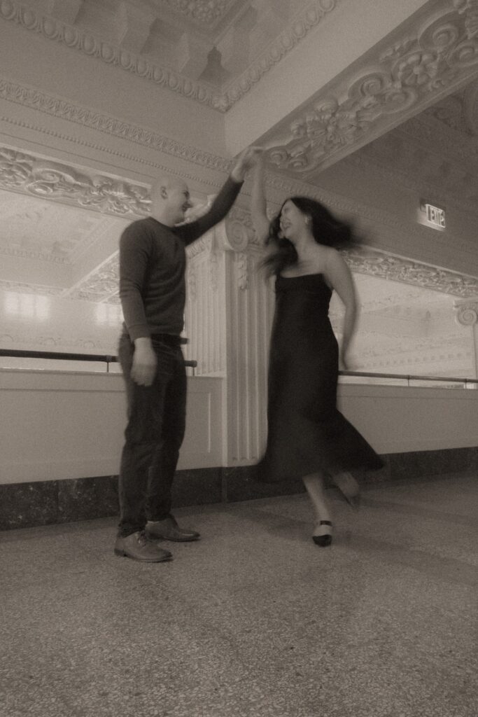 A black and white photo of a male and female dancing at King Street Station near Seattle, WA.
