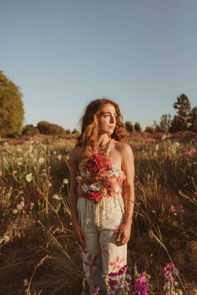 A portrait of a female with red hair wearing floral top in field at Discovery Park near Seattle, WA.
