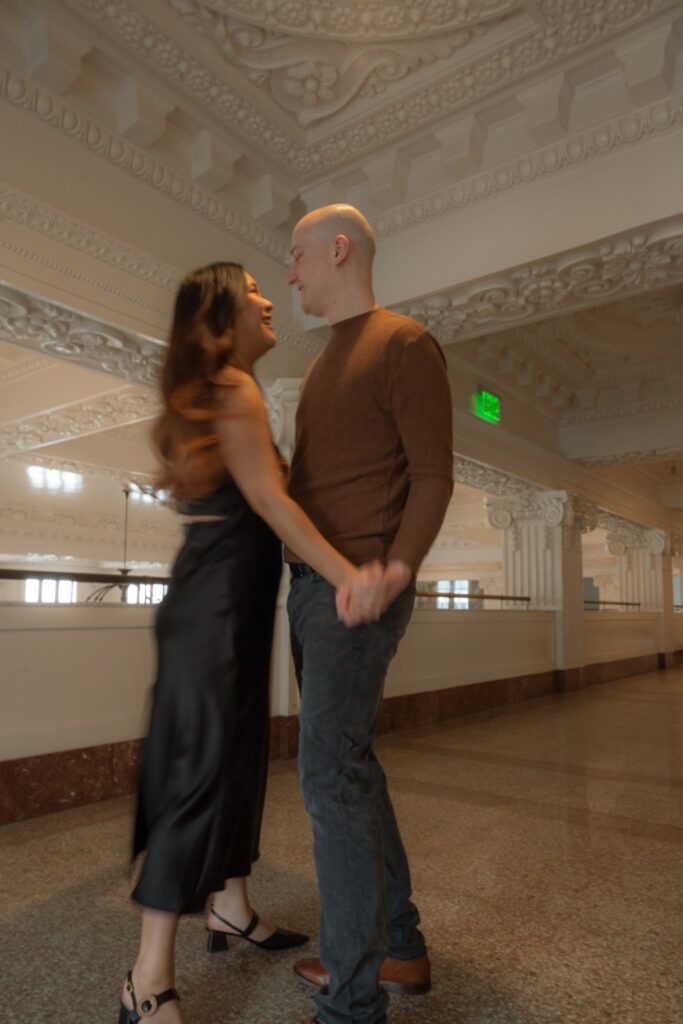 A couples portrait of a male and female dancing at King Street Station near Seattle, WA.