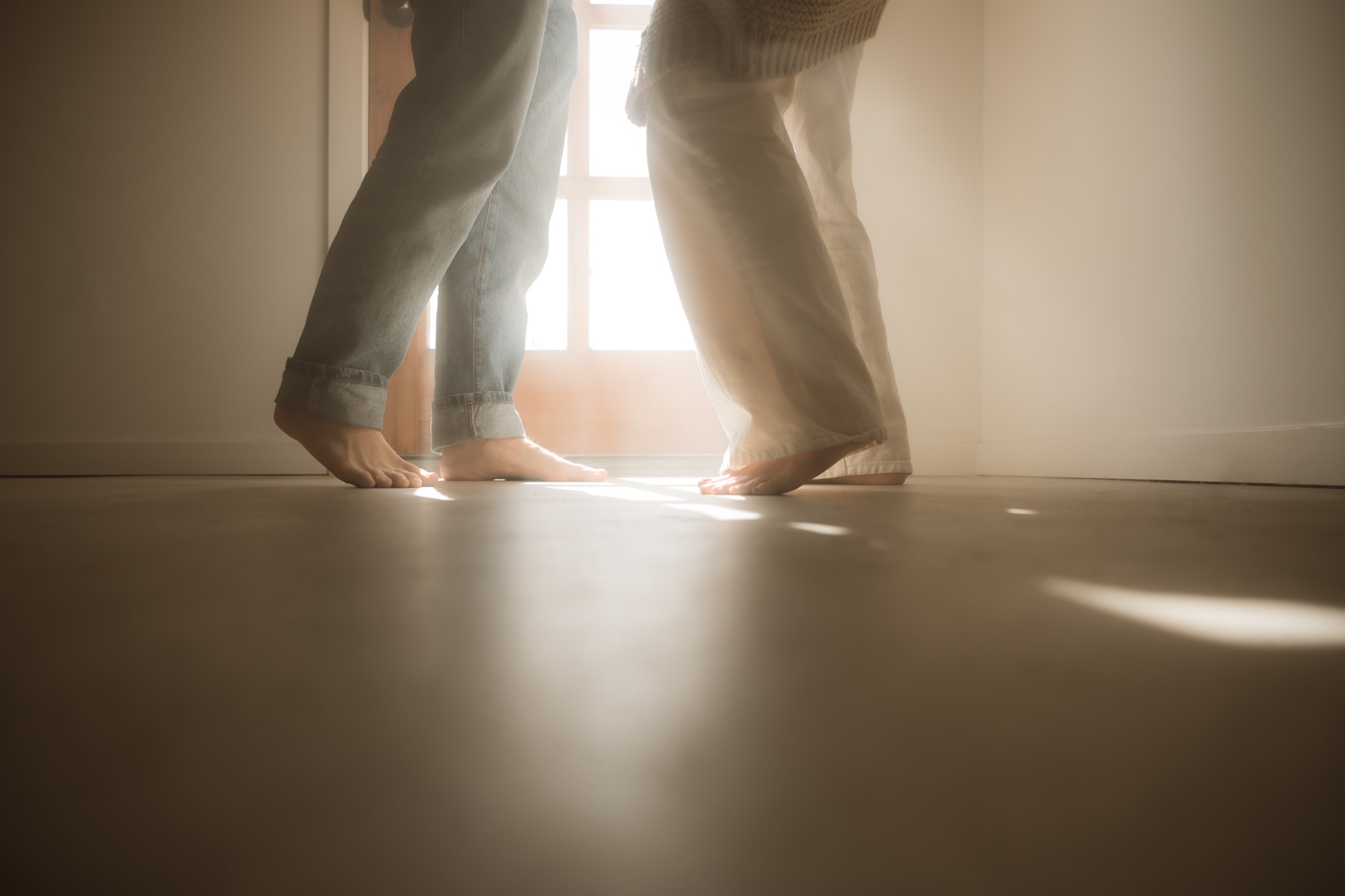 A male and female dancing in sunlit doorway at home near Yucca Valley, California.