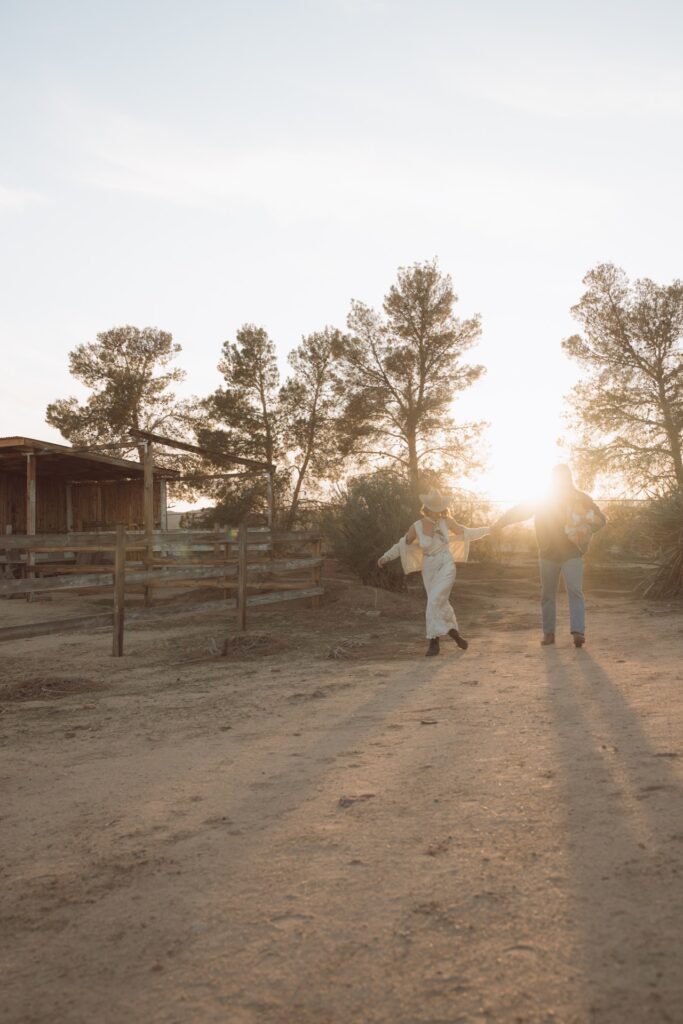 A family portrait of a male and female walking near ranch house with baby boy at sunset near Joshua Tree, CA.