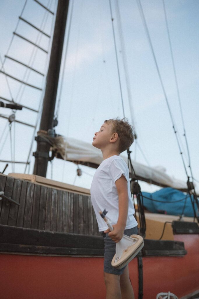Little boy holding toy sailboat