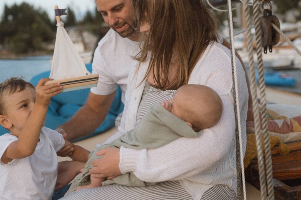 Family of four with newborn baby on vintage sailboat