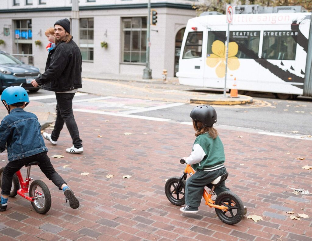 little boys riding their bikes with parents in pioneer square