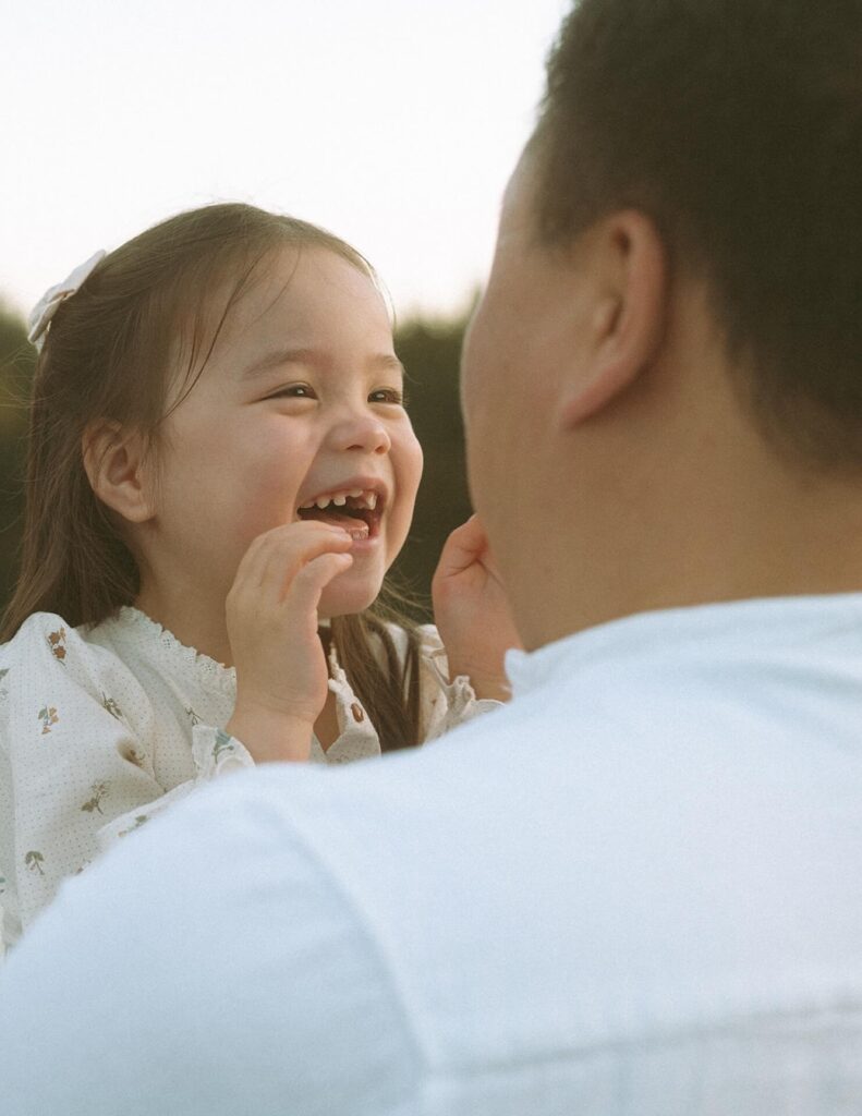 Little girl laughing in Dad's arms.