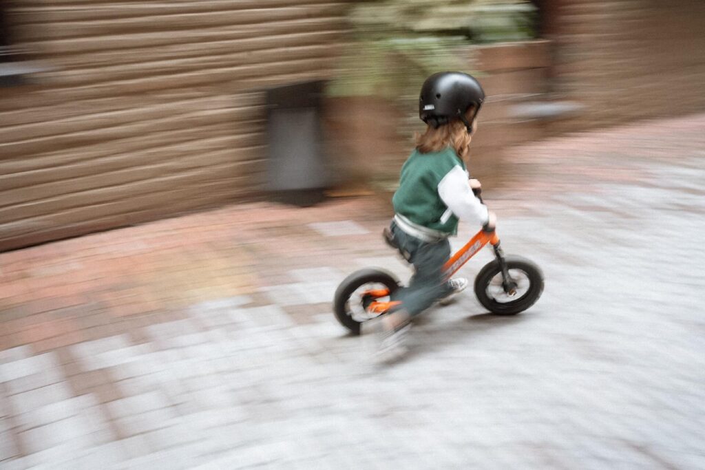 slow shutter photo of little boy riding balance bike