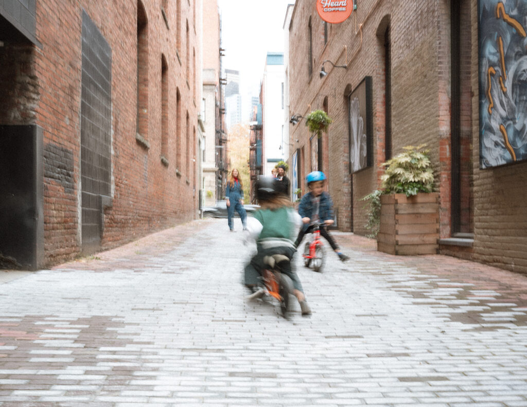 kids riding bikes in pioneer square alleyway