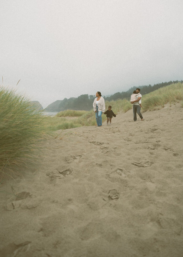 family of four walking in sand dunes at cannon beach