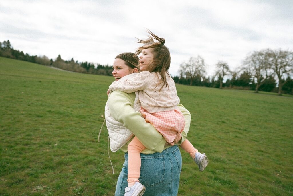 mother giving daughter piggy back ride at discovery park