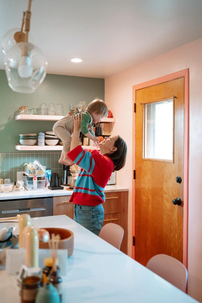 female lifting toddler in kitchen in seattle