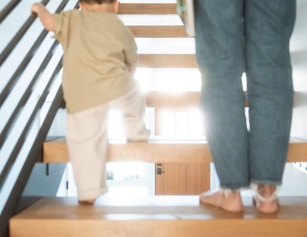 toddler walking up floating stairs with female