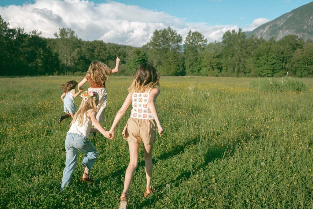 girls running in field near snoqualmie