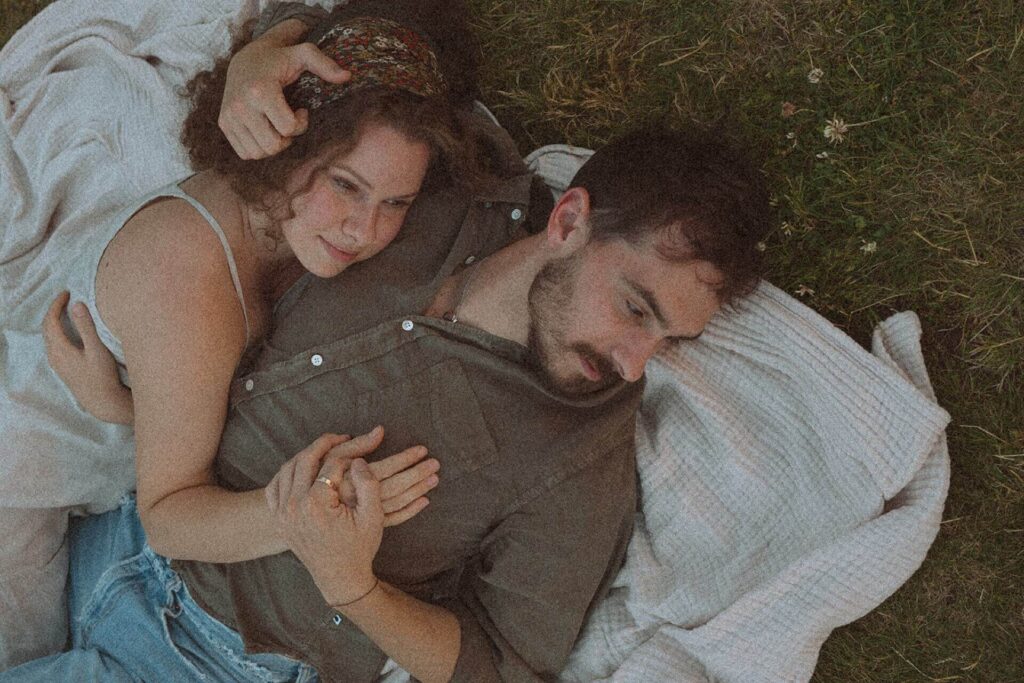 couple laying in grass at saint edward state park in kenmore