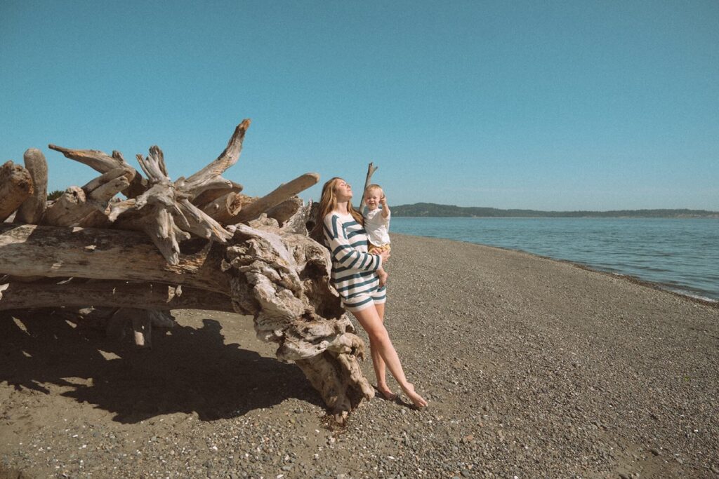 mother standing with baby on beach