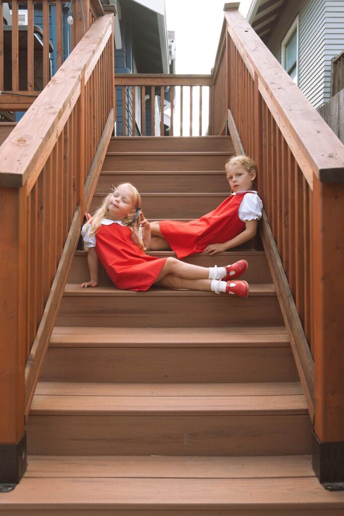 girls in red dresses sitting on stairs at home in seattle