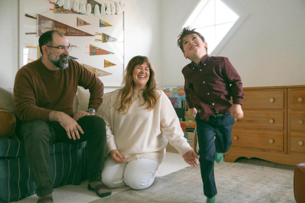 child playing in room with parents