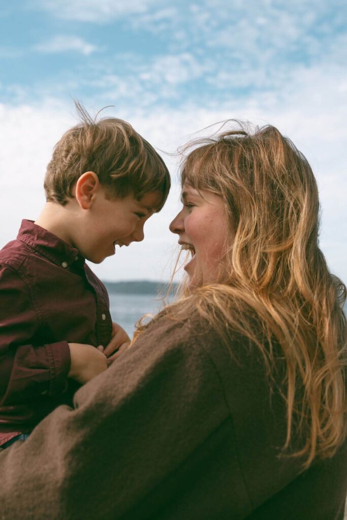 female holding little boy at beach