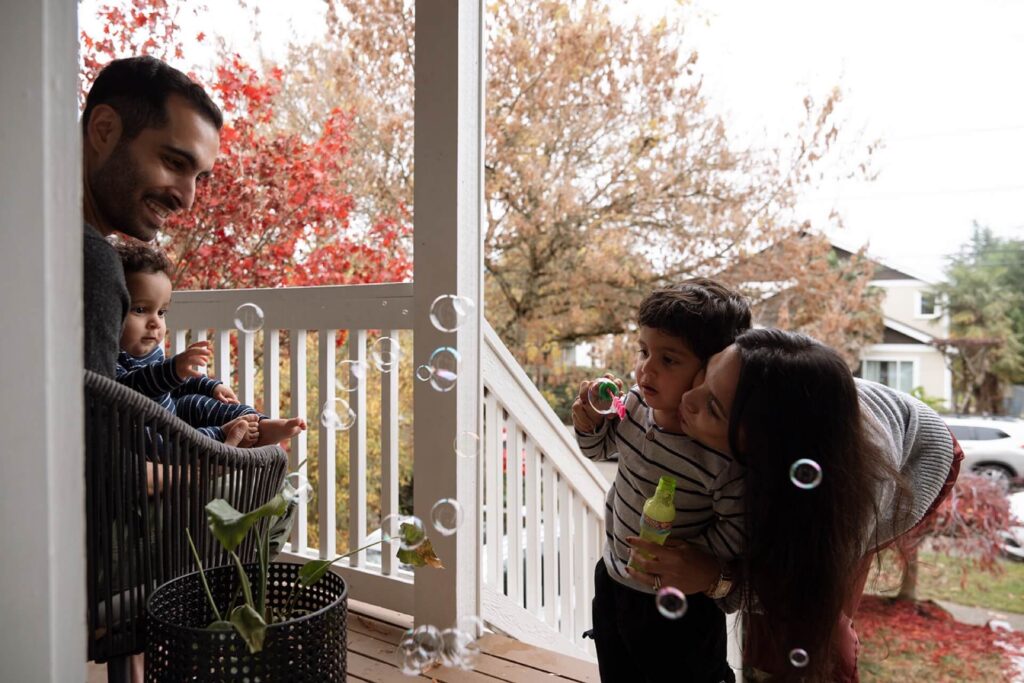 family of four blowing bubbles at home