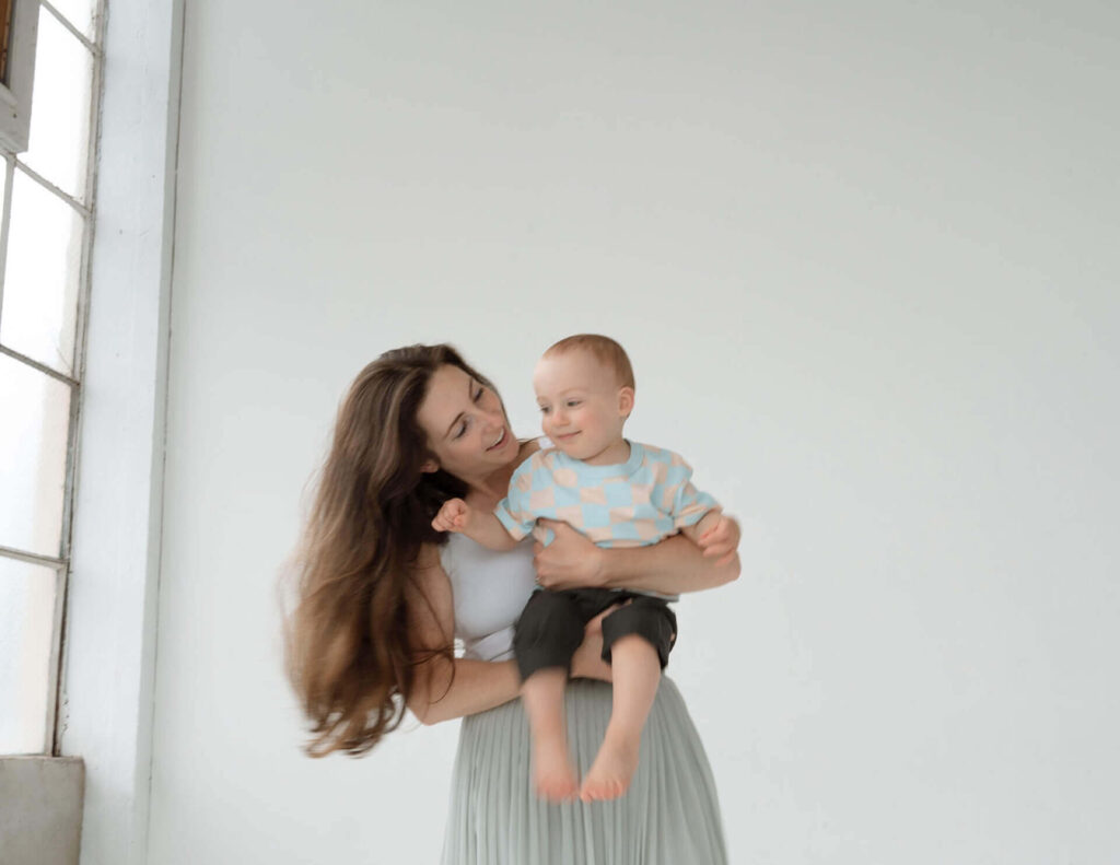 mother playing with baby son in studio