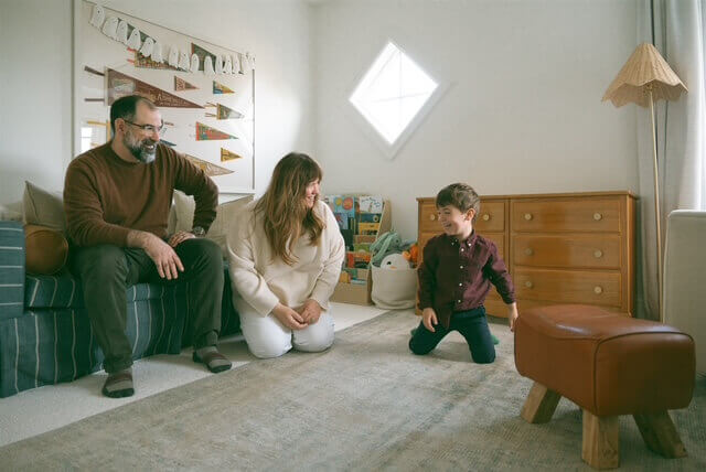 family of three playing in son's room at home