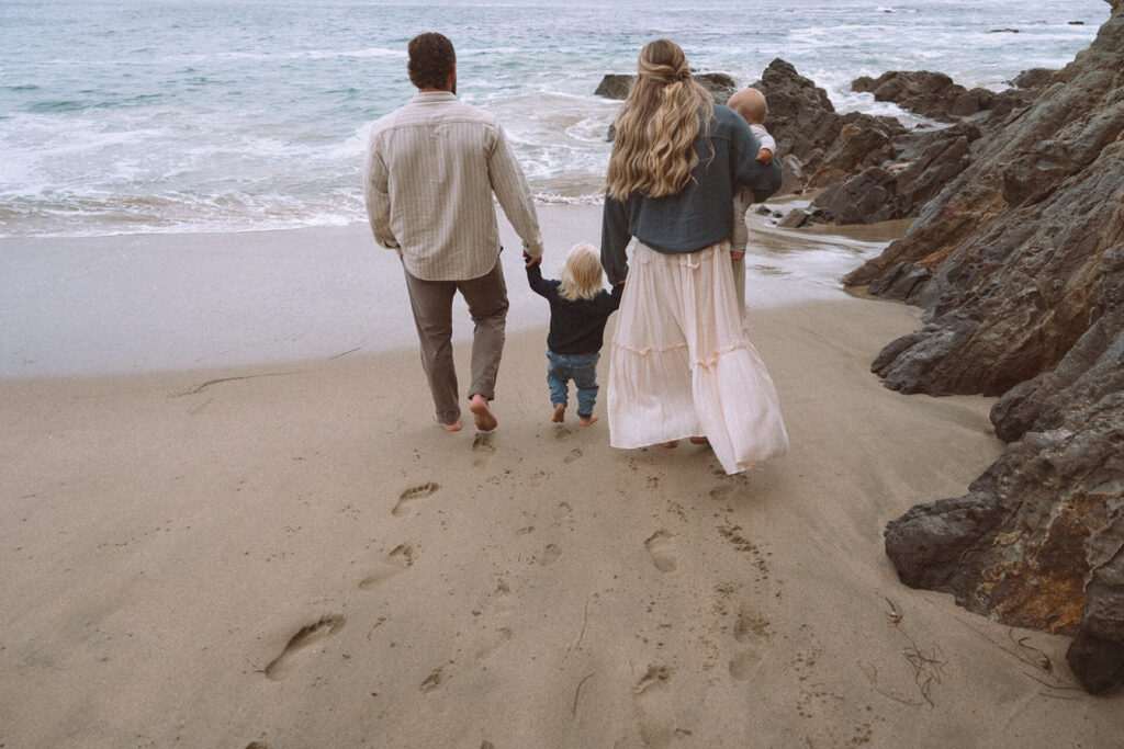 mother and father walking with two small children laguna beach
