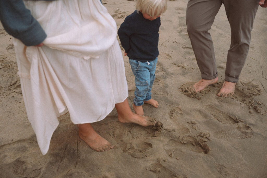 family with their feet in sand at crescent bay beach