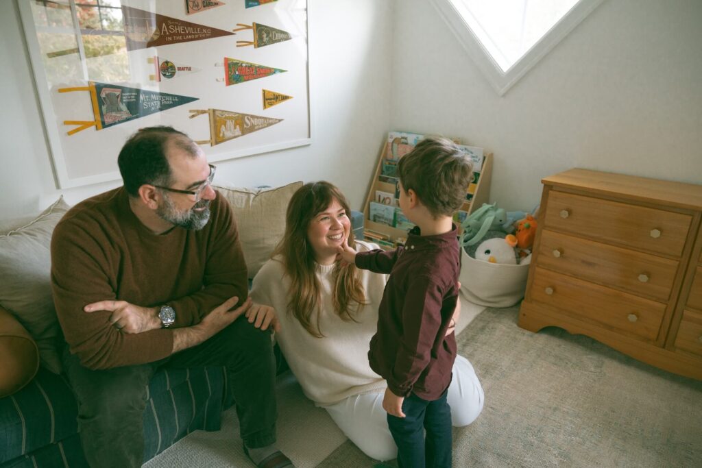 son touching mother's face in his room with family