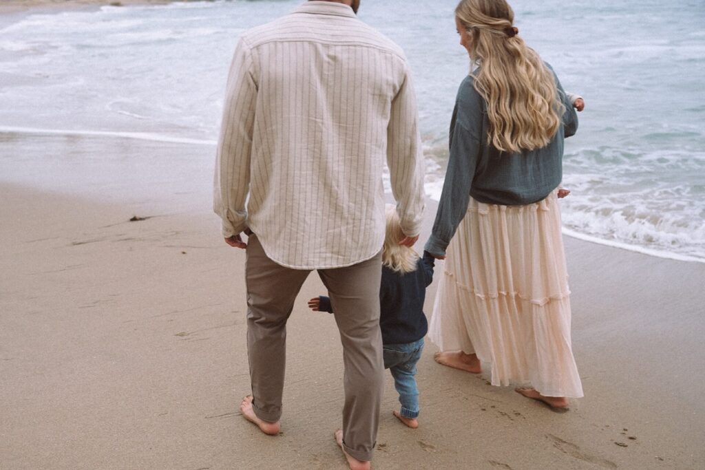 family walking on sand with two small kids crescent bay