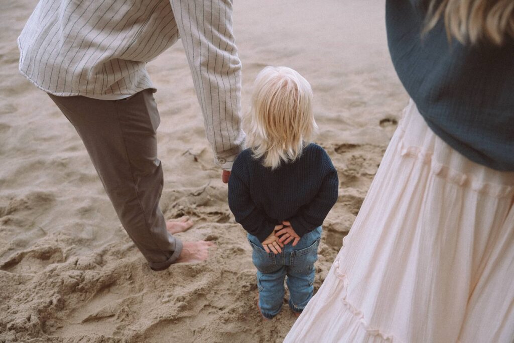 little boy wearing blue holding hands behind his back