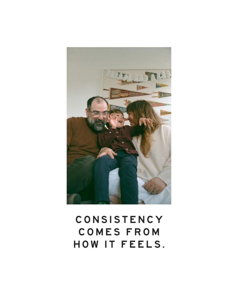 Family laughing together on a couch indoors, with text overlay: “Consistency comes from how it feels.” Candid lifestyle family photography in Orange County.