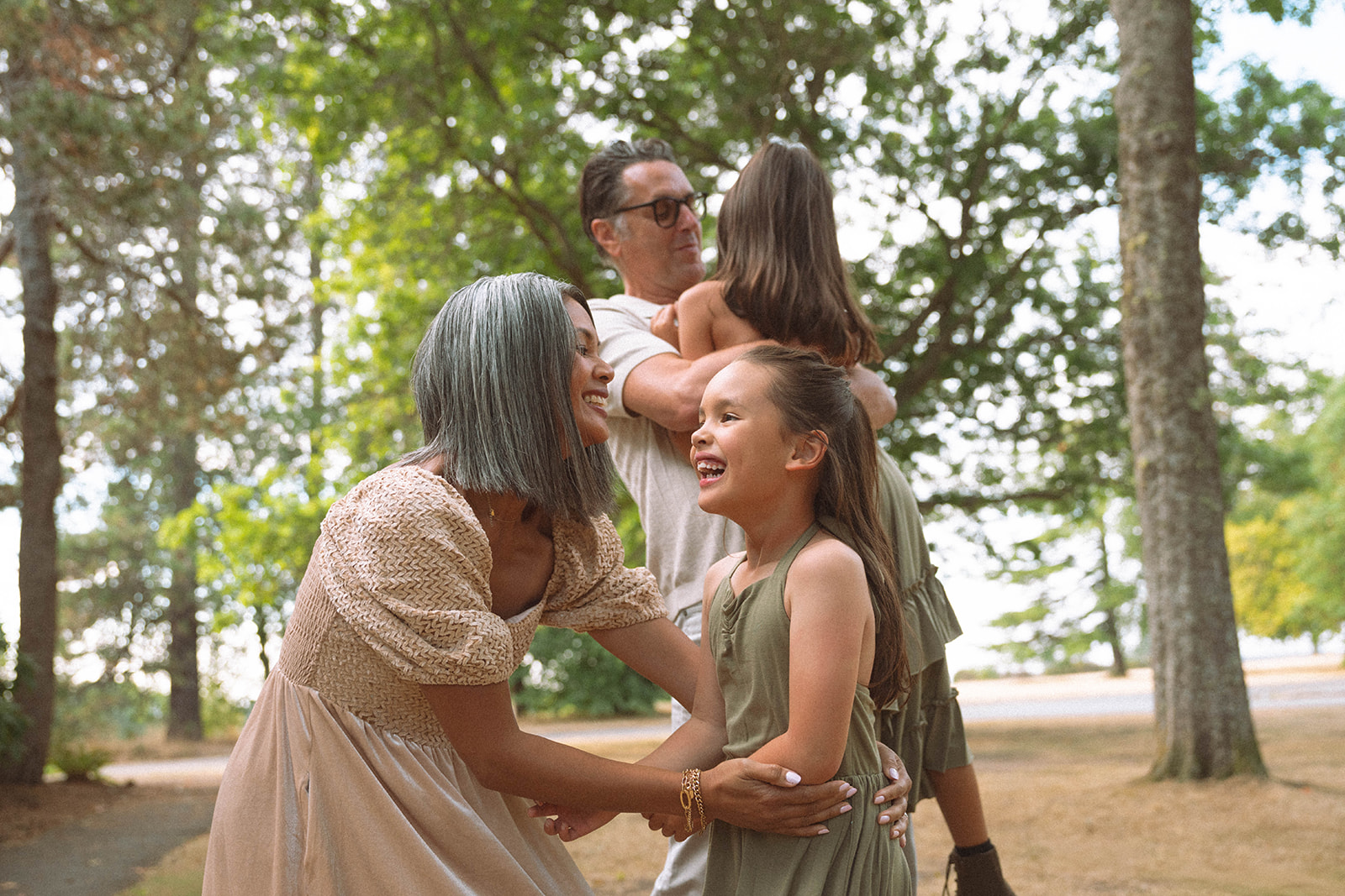 Parents playing with their daughters outdoors during a candid family photography session in Irvine, Orange County.