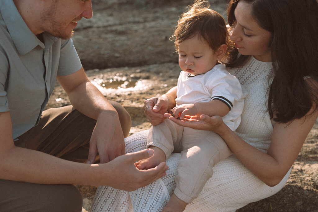 Parents looking at their baby during family photos in Laguna Beach.