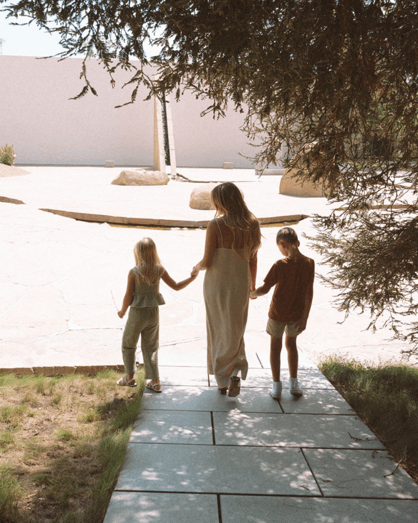 Mother walking hand in hand with her two children through the pathways of Noguchi Garden in Costa Mesa.