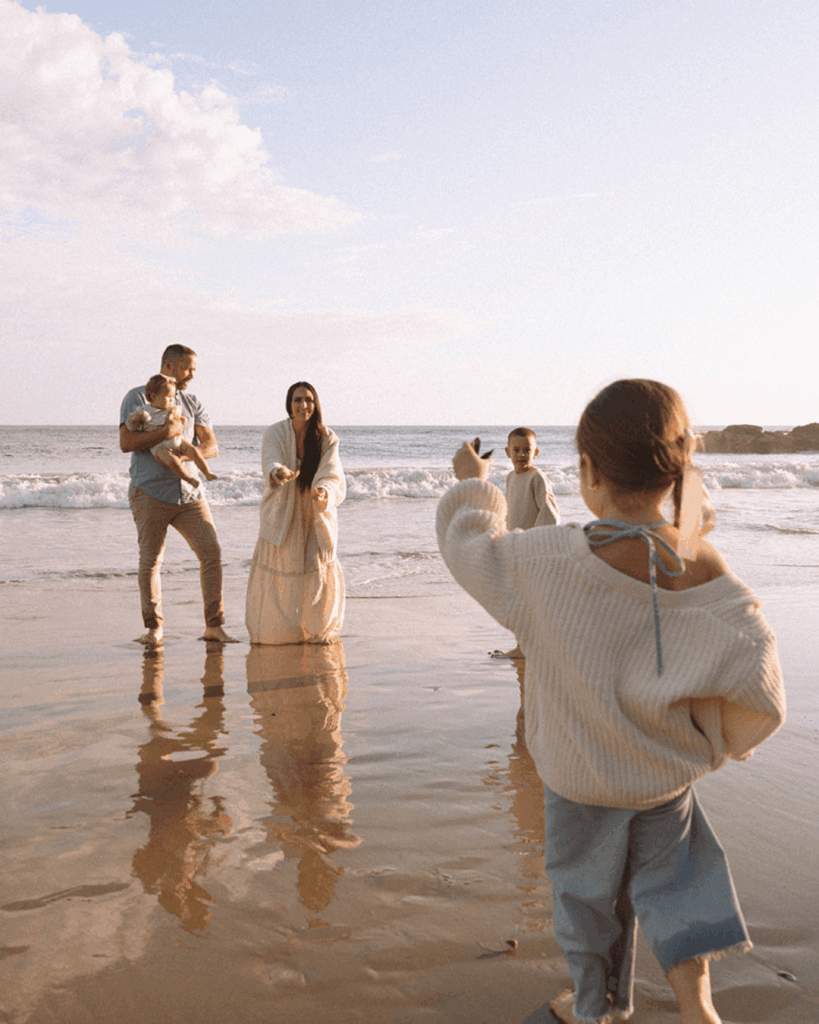A family of five playing on the shore during a golden Laguna Beach sunset, photographed by Orange County family photographer Maria Alcantara.
