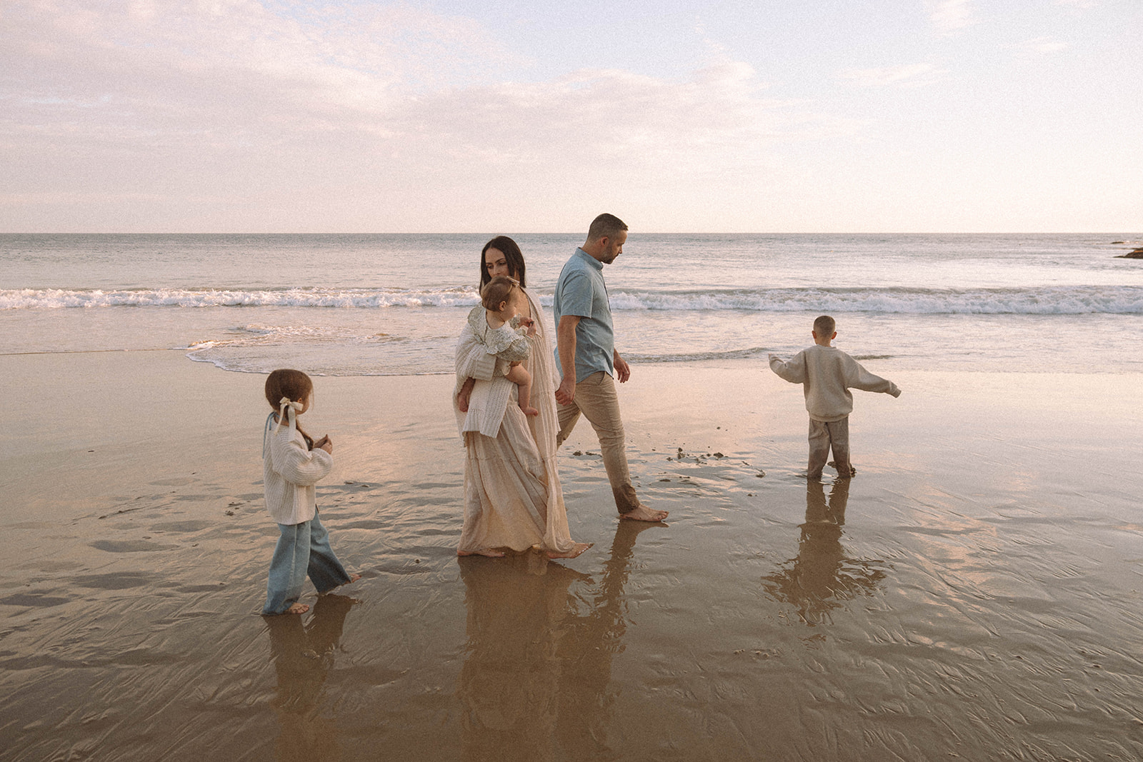 Family walking along the shoreline during golden hour at Laguna Beach, captured by Orange County family photographer Maria Alcantara — candid and relaxed family photos at sunset.