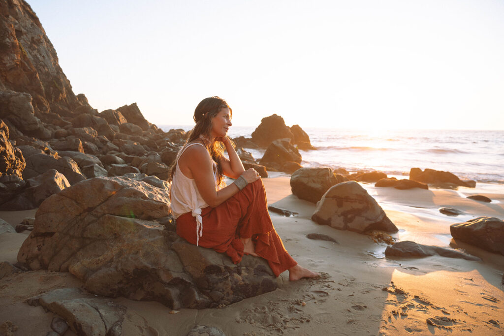 Warm, editorial-style portrait of a wellness entrepreneur taken during Laguna Beach branding photos at sunset along the Orange County coastline.