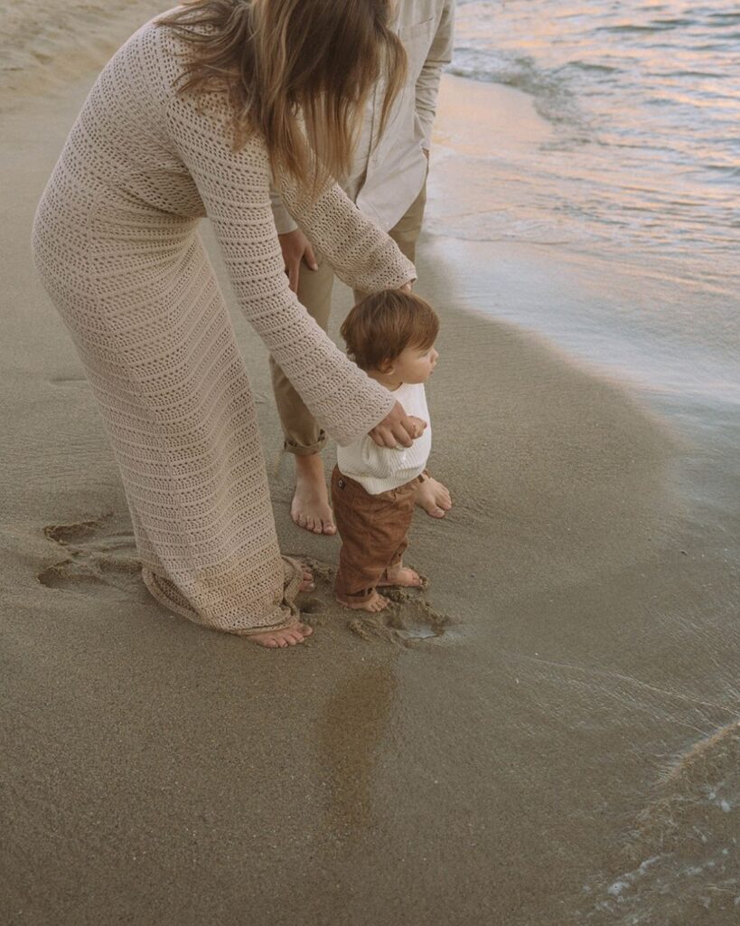 Candid family photo session in Laguna Beach with warm golden light and coastal cliffs in the background.
