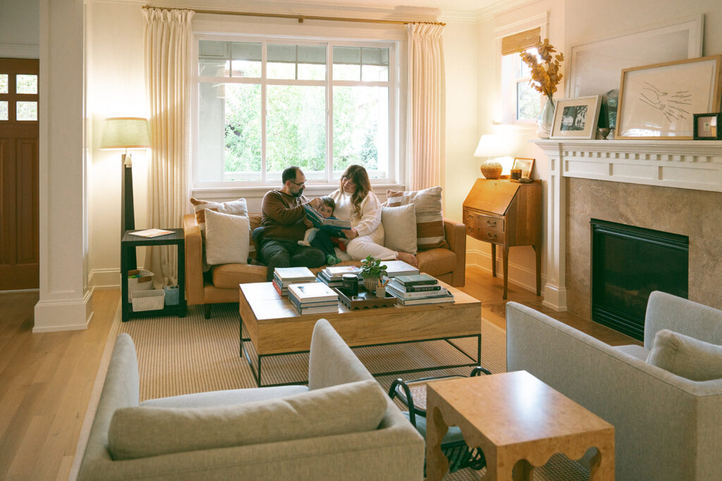 Parents reading with their child in a cozy living room during a warm and natural at-home session.