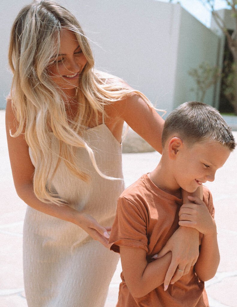 A mom gently guiding her son in soft sunlight at Noguchi Garden — a simple, heartfelt moment that fits the relaxed style of family photos in Orange County.