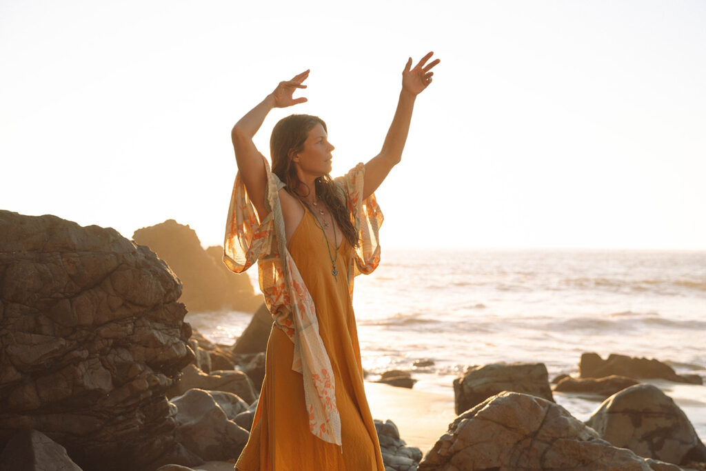 Laguna Beach branding photos of a wellness entrepreneur practicing movement and mindfulness on the beach at sunset.