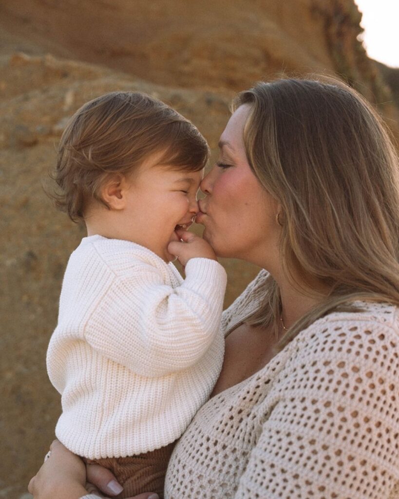 Mother holding her toddler during Goff Cove family photos along the Laguna Beach cliffs.