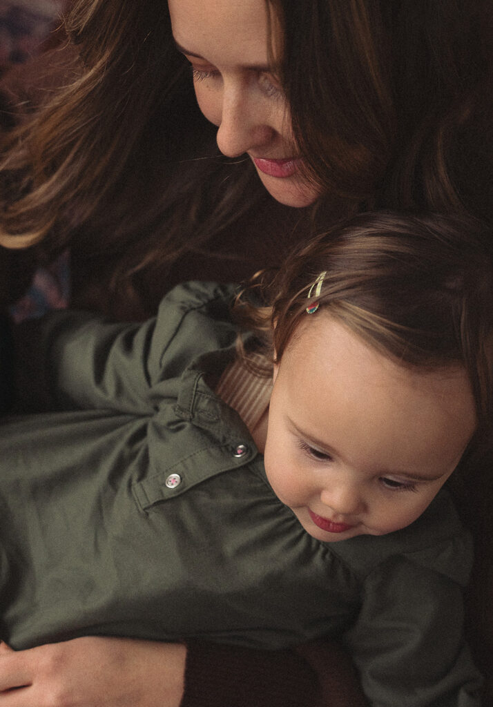 Unposed motherhood portrait of a mom and toddler sharing a quiet moment in a Santa Ana studio.