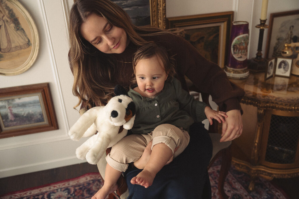 Soft, editorial motherhood photography of a mom holding her toddler in a light-filled studio.