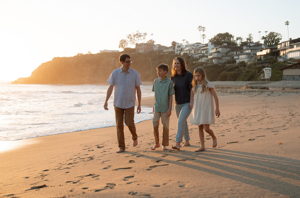 family walking along the shoreline at golden hour in Laguna Beach — candid Orange County family photography